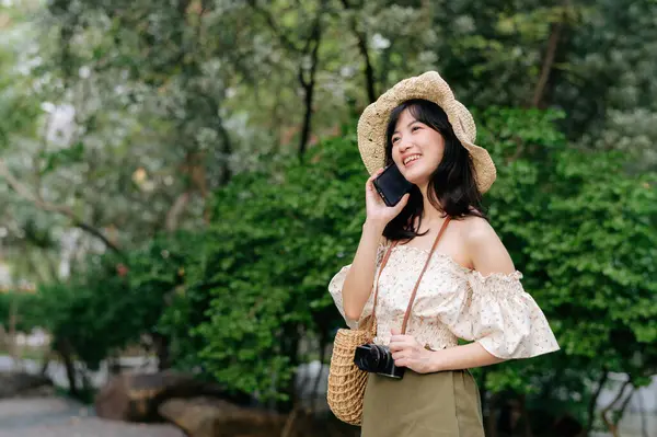 緑の公園の背景に帽子 バスケット 携帯電話やカメラを織って若いアジアの女性旅行者の肖像画 旅のライフスタイル 世界旅行探検家またはアジアの夏の観光コンセプト — ストック写真