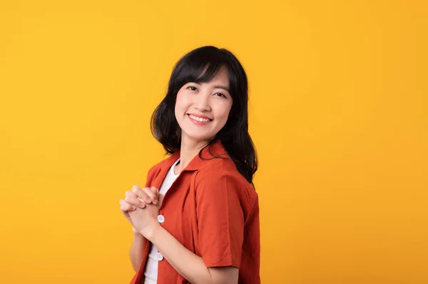 年轻美丽的亚洲女人 穿着橙色衣服 背景是黄色的 很可爱 很腼腆 — 图库照片