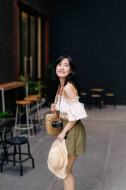 Kameralı mutlu Asyalı genç kadın hafta sonu şehir gezisine çıkıyor. Genç hippi bayan turist yaz Bangkok 'u geziyor. Asya yaz turizmi kavramı.