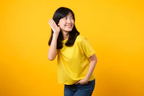 吸引了亚洲年轻女子的注意 穿着一件黄色的T恤和牛仔 弯腰去偷听和倾听 激起了好奇心和好奇心 引人注目的促销和折扣 — 图库照片
