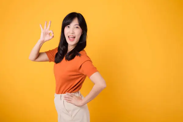 Promieniująca Pozytywność Azjatycka Wesoła Kobieta Trzydziestce Pomarańczowej Koszuli Pokazuje Porządku — Zdjęcie stockowe