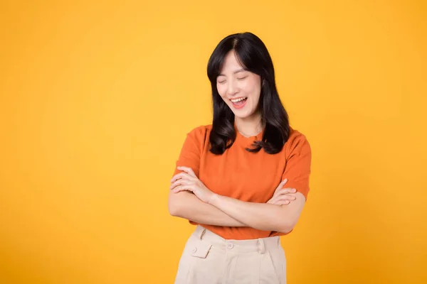 黄色の背景に隔離された交差した腕のサインジェスチャーを示すオレンジ色のシャツを着ている30代のアジアの女性 ハンドジェスチャーコンセプトを持つ自信のある女性 — ストック写真