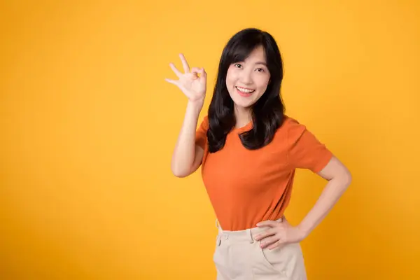 30多岁的亚洲女人穿着黄色背景的橙色衬衫 炫耀自己的积极正面形象 手势概念 — 图库照片