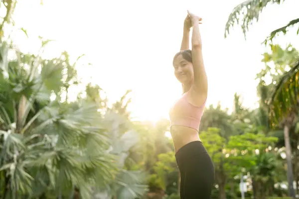 30多岁的年轻亚洲女子穿着粉色运动服 会玩瑜伽和伸展肌肉 日落时分 在公园里与健身瑜伽女孩拥抱健康的户外生活方式 福利和福利概念 — 图库照片