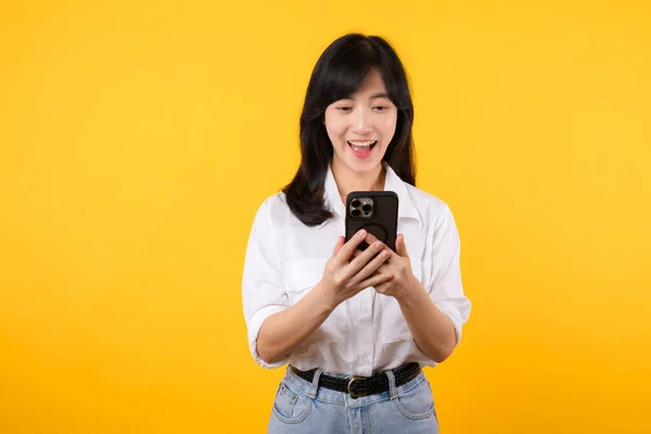 Zaskoczona Młoda Azjatka Używająca Telefonu Komórkowego Pozytywnym Wyrazem Twarzy Uśmiechnięta — Zdjęcie stockowe