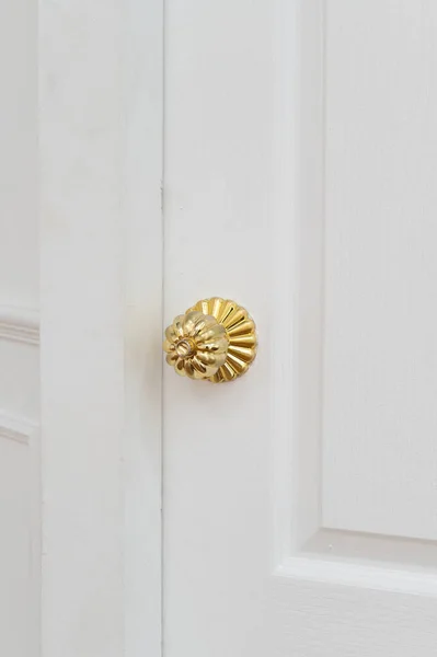 gold door knob handle. reflective surface and modern design add touch of luxury to entrance door. Crafted with wood and metal, this round knob shines with style and security.
