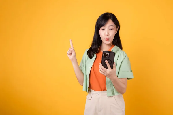 Aplikacje Mobilne Wesołą Młodą Azjatką Trzydziestce Noszącą Pomarańczową Koszulę Szczęśliwie — Zdjęcie stockowe