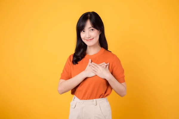 Glada Unga Asiatiska Kvinna Bär Orange Skjorta Håller Händerna Bröstet — Stockfoto