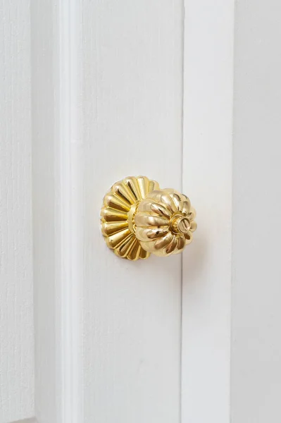 gold door knob handle. reflective surface and modern design add touch of luxury to entrance door. Crafted with wood and metal, this round knob shines with style and security.