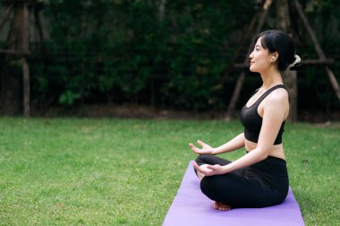 Meditasyon vahası. Ormanın sonsuzluğunun ortasında, 30 'lu yaşlarda bir kadın yoga yapar, rahatlama ve iç uyumu benimser..
