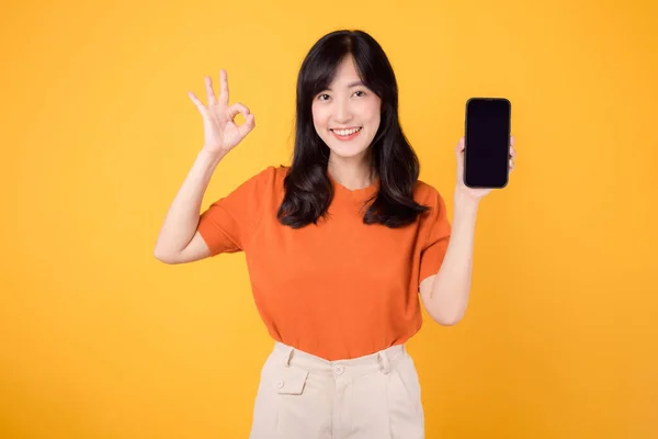 Wesoła Młoda Azjatka Trzydziestce Ubrana Pomarańczową Koszulę Pokazuje Porządku Gest — Zdjęcie stockowe