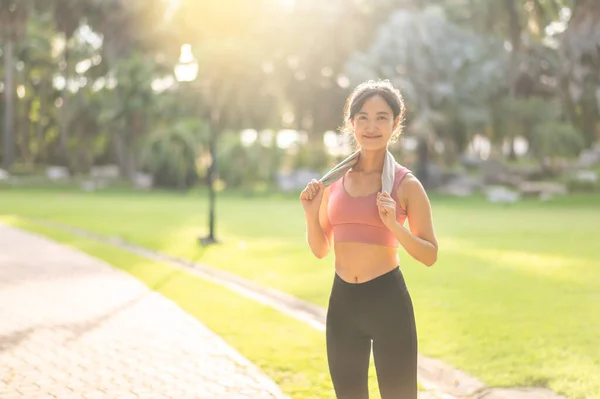 fit female jogger, happy Asian woman 30s in sportswear, enjoying a refreshing sunset run in nature. Embrace the concepts of fitness, health, and motivation with this captivating silhouette.