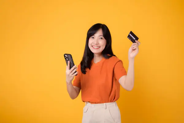 Selbstbewusste Asiatin Ihren Dreißigern Orangefarbenem Hemd Smartphone Und Kreditkarte Auf — Stockfoto