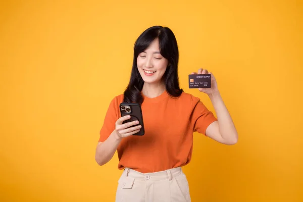 Enthusiastic Asian Woman 30S Using Smartphone Showing Credit Card Yellow — Stock Photo, Image