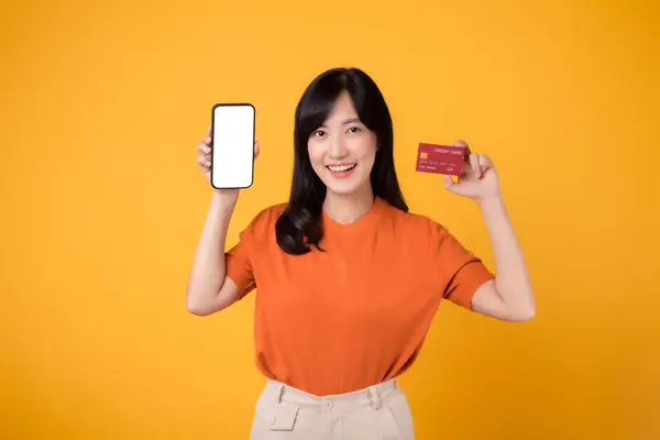 Mulher Asiática Dinâmica Anos Revelando Smartphone Cartão Crédito Fundo Amarelo — Fotografia de Stock