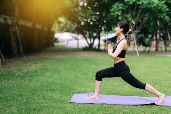 Embrace holistic well-being with outdoor yoga and fitness. A young asian woman wearing sportswear stretching muscle in park and finds balance, vitality, and serenity in nature\'s embrace.