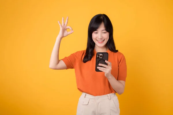 Energetische Asiatin Die Orangefarbenes Hemd Smartphone Mit Handzeichen Auf Leuchtend — Stockfoto