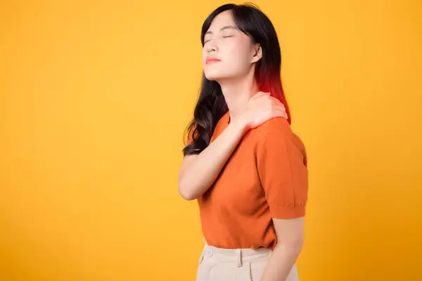 ネックアチェ療法医療オフィス症候群のコンセプト オレンジ色のシャツを着て 心配している若いアジアの女性30代は 黄色の背景に彼女の痛みの肩を保持します — ストック写真