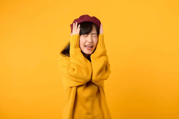 Inmitten Des Trubels Lauscht Eine Stylische Asiatische Dame Gelbem Pullover lizenzfreie Stockfotos