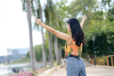 Turuncu gömlekli zarif bir bayan olarak yalnızlığın ve sevincin gücünü hisset. Açık havada ferahlatıcı bir anın tadını çıkar. Tasasız yaşamanın özünü yakala..