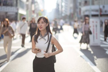 Tokyo 'ya bağlanan Japon bayan, akıllı telefonuyla şehri geziyor, bağlantı ve şehir keşiflerinin bir karışımı..