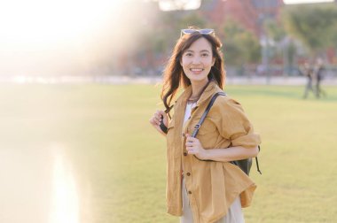 Gezgin Asyalı 30 'lu yaşlardaki kadın gün batımının altın parıltısıyla yıkanmış, keşif özgürlüğünü kucaklıyor. Tatil tatili gezisinde Bangkok, Tayland