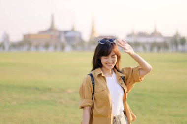 Gezgin Asyalı kadın 30 'larında Wat Pra Kaew' i keşfediyor. Büyüleyici bir mimariden, dost canlısı yerel halka kadar her anı kalbinde ve kamerasında yıllarca sevgiyle anacak..