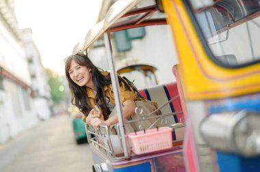 Çekici güzel turist kadın ya da gezgin kadın Tuk Tuk taksisinde oturuyor yaz tatillerinde şehri keşfediyor, Khao San Yolu Bangkok, Tayland 'da yürüyüş caddesi..