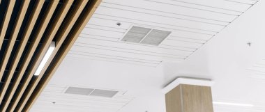 Tavana monte edilmiş kaset tipi klima ve beyaz tavanda modern lamba ışığı. Ofis ya da ev havalandırması