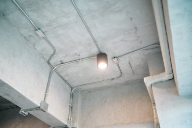 Endüstriyel aydınlatma armatürü ile korunmasız bir beton tavan