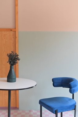 Modern mobilyalar ve şık dekorlarla dolu rahat bir ev. Beyaz bir vazoda turuncu ve yapay çiçek buketi ile doğanın dokunuşunu ekleyin. Konut kavramında lüks ve rahatlama.