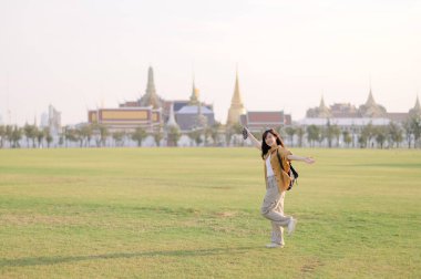 Gezgin Asyalı 30 'lu yaşlarda, sırtında bir çantayla Wat Pra Kaew' i çocuksu bir mucizeyle keşfediyor. Altın çatılarda gün ışığı dans eder, ve kaygısız bir gülümseme