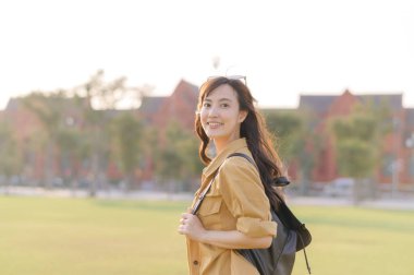 Gezgin Asyalı 30 'lu yaşlardaki kadın gün batımının altın parıltısıyla yıkanmış, keşif özgürlüğünü kucaklıyor. Tatil tatili gezisinde Bangkok, Tayland