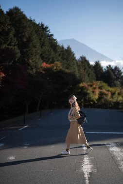 Sıradan bir elbise şıklığı, Tokyo 'da Fuji Dağı' nın yanında Asyalı bir kadın, şehir kalabalığında şık bir portre yapıyor, Tanuki Gölü 'nün manzaralı güzelliği, keyfi ve gülümsemesiyle tatilin tadını çıkarıyor..