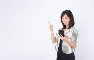 Güneydoğu Asyalı kadın internet uygulamalarını araştırırken mutlu bir şekilde cep telefonunu kullanıyor.