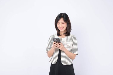 Güneydoğu Asyalı kadın internet uygulamasına erişmek için rahat bir şekilde cep telefonu kullanıyor.