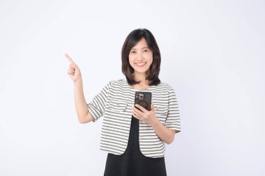 Cep telefonu tutarken gülümseyen Güneydoğu Asyalı kadın ve parmağıyla internet başvurusu kullanımını parlak stüdyo ortamında gösteren