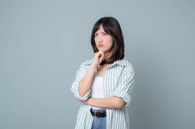 Düşünceli ifadeli Güneydoğu Asyalı kadın, çevrimiçi alışveriş yaparken yaratıcı perakende sektöründeki küçük işletmesi için yeni fikirler düşünüyor.