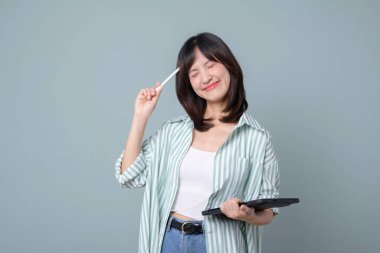 Yaratıcı Güneydoğu Asyalı kadın, internet perakende sektörünü temsil eden ve başarıyı depolayan, elinde tablet ve stil ile küçük işletmesini mutlu bir şekilde planlıyor.