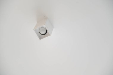 Minimalist tavan lambasına yakın plan, çağdaş iç dekorasyonlar için mükemmel, temiz beyaz tavana monte edilmiş basit ama modern bir tasarım sergiliyor.