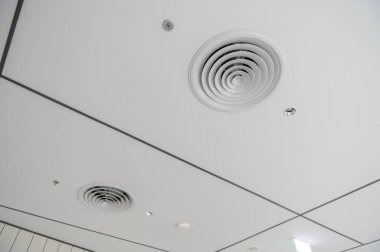 Temiz modern ofis tavanı dairesel hava delikleri, durgun aydınlatma ve beyaz panellerle şebeke deseni ticari alanda parlak ve işlevsel tasarım yaratıyor.