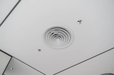 Dairesel havalandırma, tenha aydınlatma ve beyaz paneller ile ızgara desen ve parlak ve işlevsel tasarım yaratan temiz, modern ofis tavanı