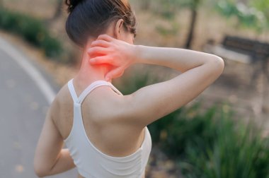 Güneydoğu Asya 'lı bir genç kızın dışarıda rahatsız bir şekilde boynunu tutarken sağlık için koşması ve ağrı hissetmesi halk parkında bir spor aktivitesi.