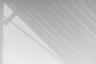 Işık duvarı yüzeyinde çapraz gölgeler bırakan bir güneş ışığı. Doğal ışık tarafından oluşturulan paralel çizgilerin soyut geometrik deseni. sakin arkaplan dokusu minimalist tasarım projeleri için mükemmel