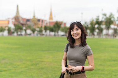 Güneydoğu Asyalı gülümseyen bir genç blog yazarı dünya turizminden zevk alıyor. Bangkok Tayland 'da yerel kültür deneyimi konseptine sahip mutlu kaşif Asya' ya seyahat için