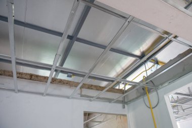 Umut verici bir iç yenileme projesi alüminyum tavan iskeleti ve elektrik kabloları kurulumunu gösteriyor. Yeni oda için yapıda ve sistemde ilerleme görülüyor