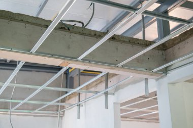 İç yenileme çalışmaları, modern konut inşa projesi için karmaşık elektrik kablolarına sahip alüminyum tavan iskeletinin dikkatli kurulumunu gösteriyor