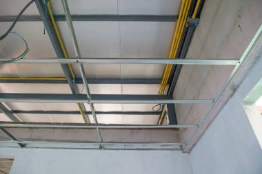 Alüminyum tavan iskeleti içinde elektrik tesisatı kurulumunu gösteren özenli bir iç yenileme. süreç modern inşa projesinin yapısal ilerlemesini ayrıntılarıyla anlatır