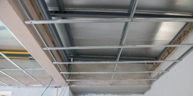 Elektrik kablolarını ve alüminyum tavan iskeletini gösteren bir iç yenileme. Kurulum, büyük yenilenme projesinin bir parçası olarak ham endüstriyel yapılanma hissi bırakıyor