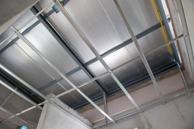 İç yenileme sırasında alüminyum tavan iskeleti titiz bir elektrik kablosu kurulumunu gösteriyor. ızgara sistemi modern bina güncellemesi için termal yalıtımı destekler